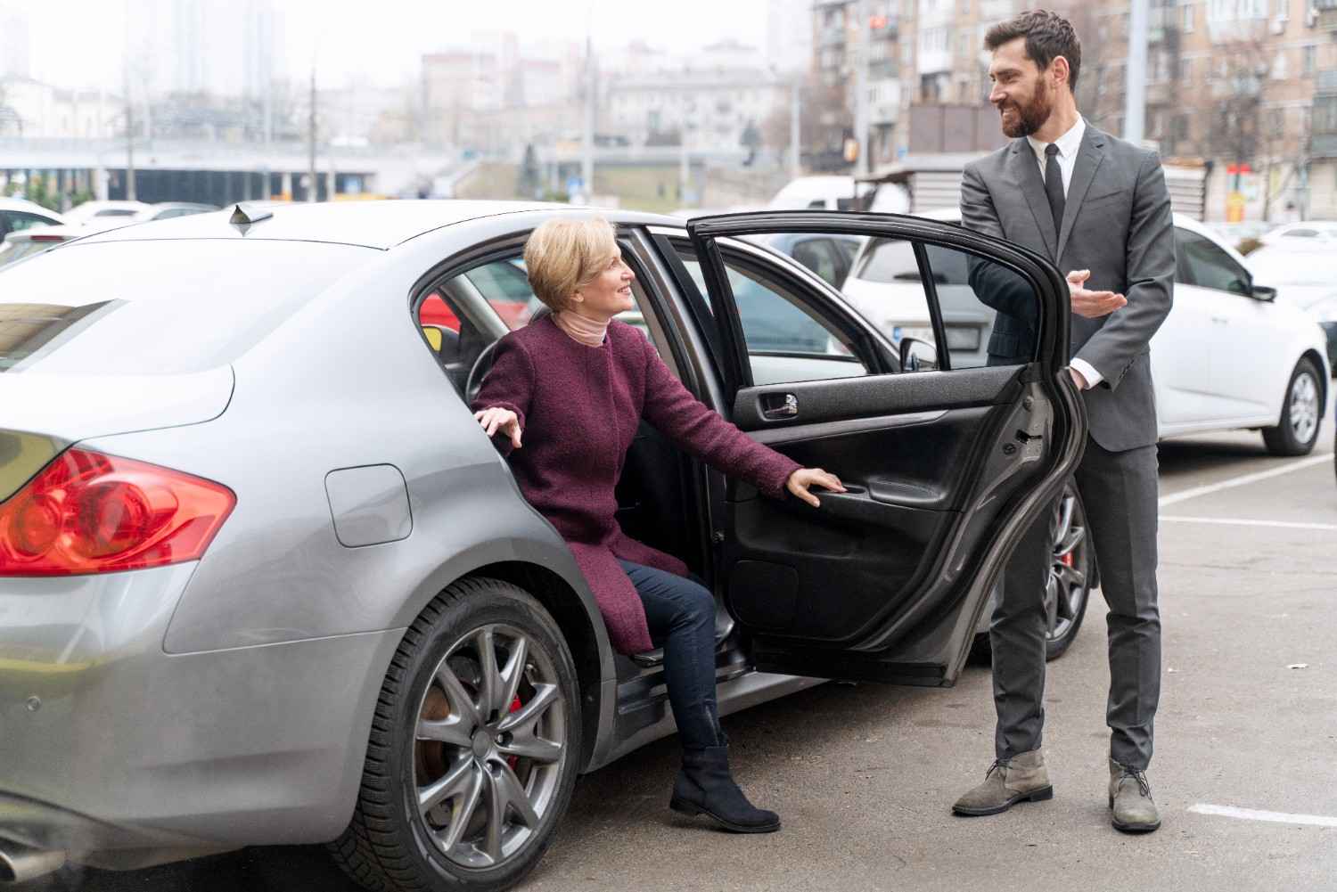 A cab driver opening door for customer at the airport - Airport Taxi Huddersfield