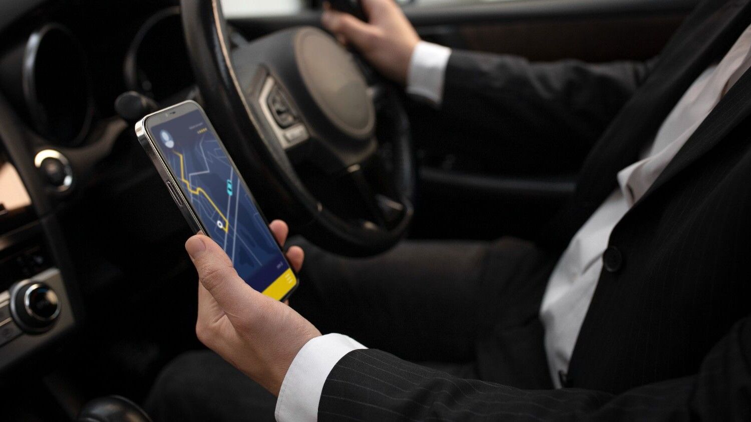 Airport Taxi Huddersfield driver checking the route to airport on his phone.